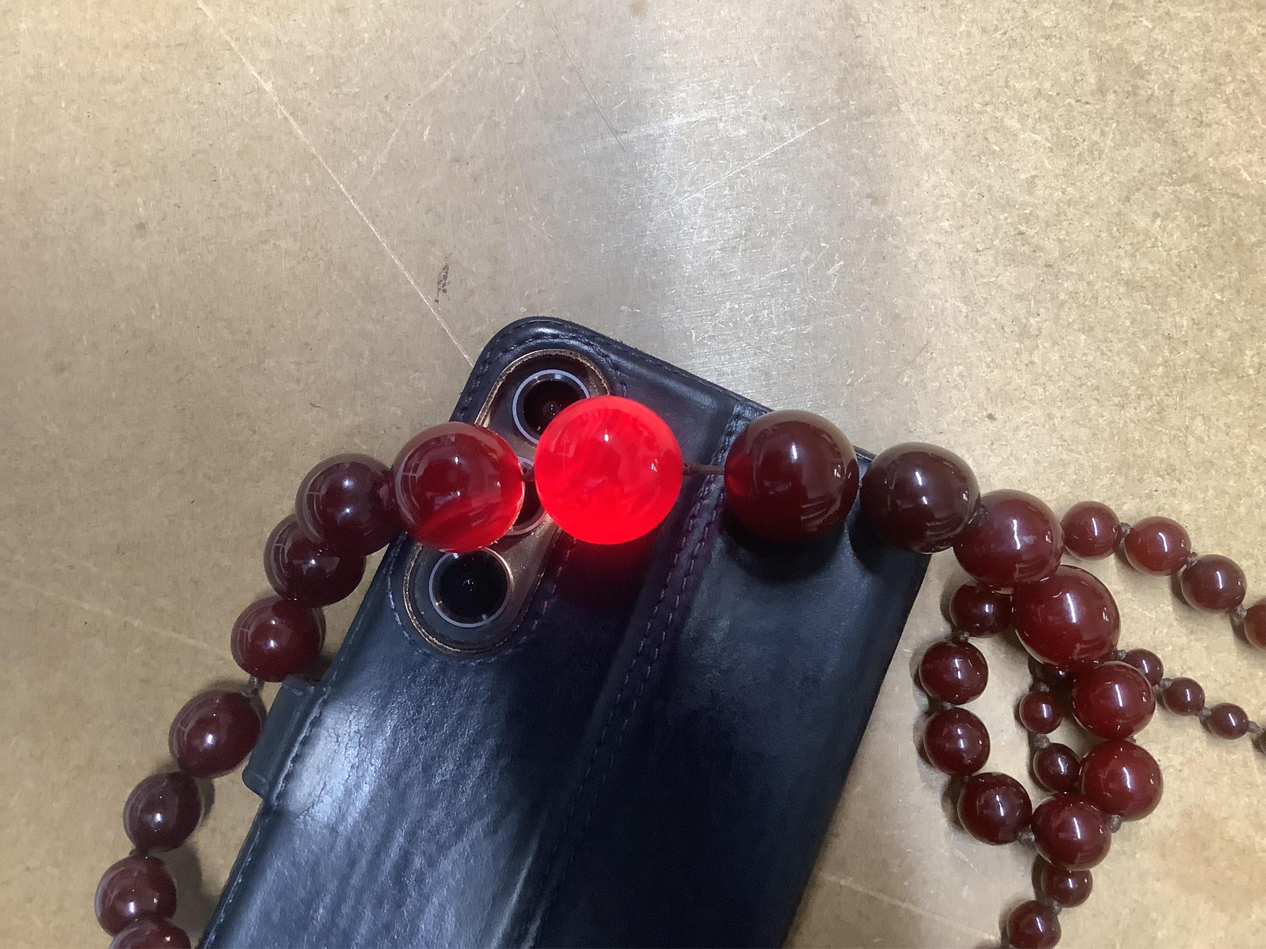 A cherry bakelite 'amber' necklace, composed of graduated spherical beads measuring approximately 6.7-23mm diameter, length approximately 86cm, gross weight 72 grams.